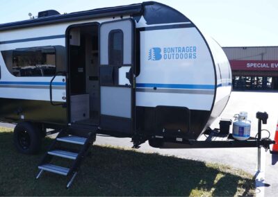 full view of the entrance side of the 21' camper, with the door open and the stairs down